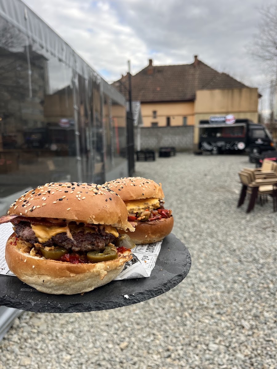 Doi burgeri Foodie cu bacon și cheddar pe terasa din Arad